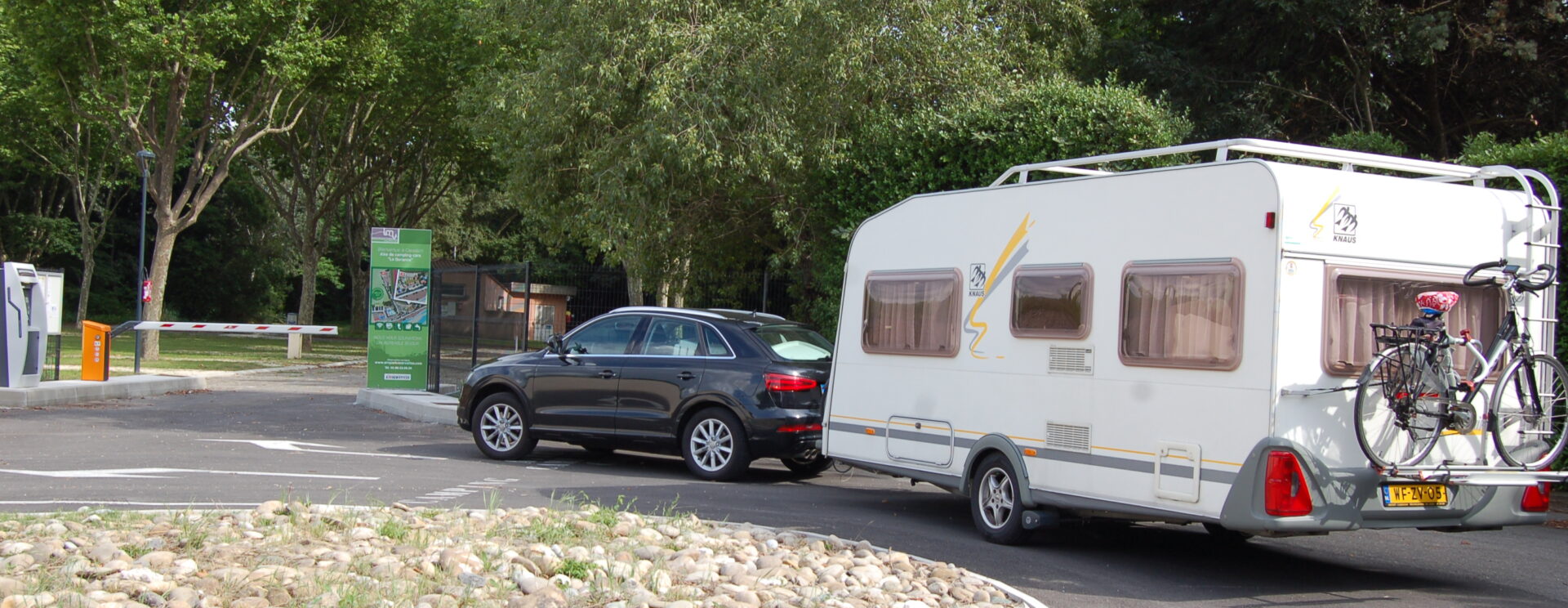Une voiture tire une caravane à l'entrée du camping La Durance de Cavaillon