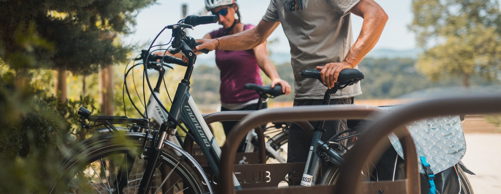 Deux cyclistes en train d'accrocher leur vélo électrique à un rack