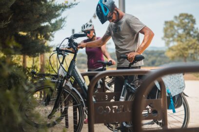 Deux cyclistes en train d'accrocher leur vélo électrique à un rack - Agrandir l'image, fenêtre modale