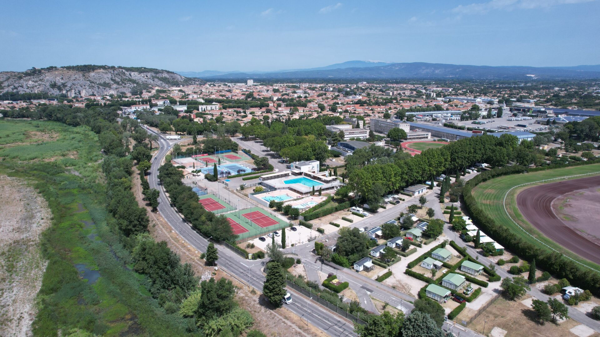 Vue drone du camping avec en arrière plan la ville, la colline Saint Jacques et le Luberon